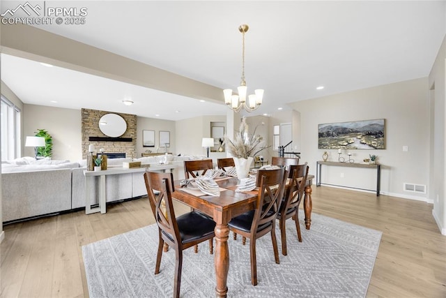 dining area featuring light wood-style flooring, recessed lighting, a notable chandelier, visible vents, and baseboards