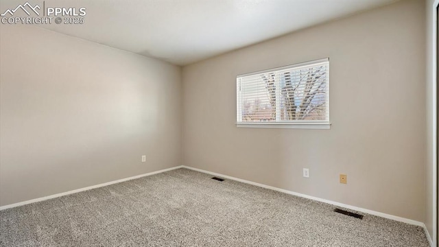 empty room featuring carpet, visible vents, and baseboards