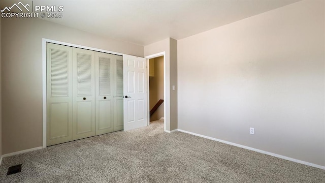 unfurnished bedroom featuring a closet, baseboards, and carpet floors