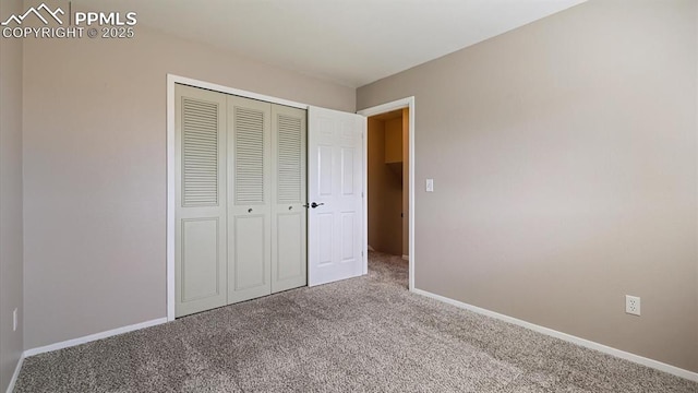 unfurnished bedroom with a closet, baseboards, and carpet flooring