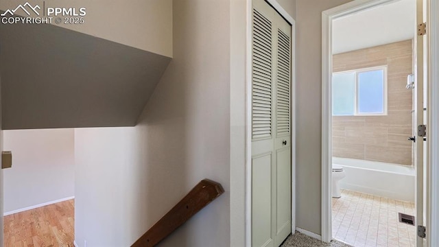 hallway with baseboards and visible vents