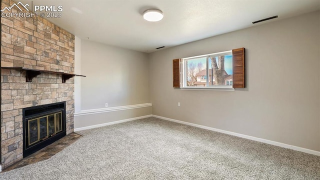 unfurnished living room with carpet, a fireplace, visible vents, and baseboards