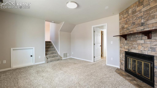 unfurnished living room with visible vents, baseboards, stairs, carpet floors, and a fireplace