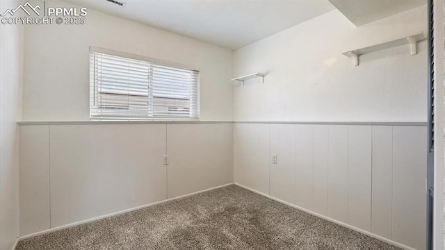 empty room with wainscoting and carpet floors