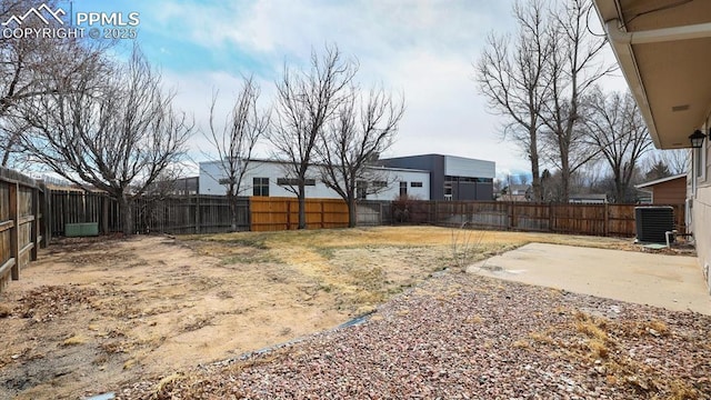 view of yard featuring a fenced backyard, central AC unit, and a patio