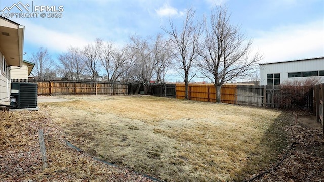 view of yard with a fenced backyard and central AC