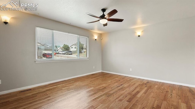 unfurnished room featuring baseboards and wood finished floors