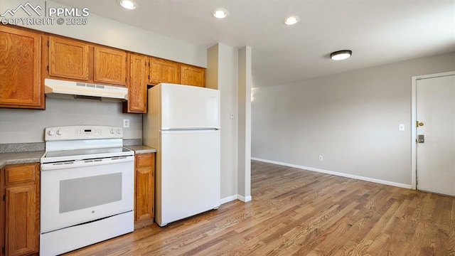 kitchen featuring under cabinet range hood, recessed lighting, white appliances, brown cabinetry, and light wood finished floors