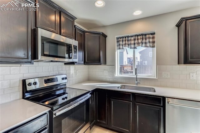 kitchen featuring recessed lighting, a sink, stainless steel appliances, light countertops, and tasteful backsplash