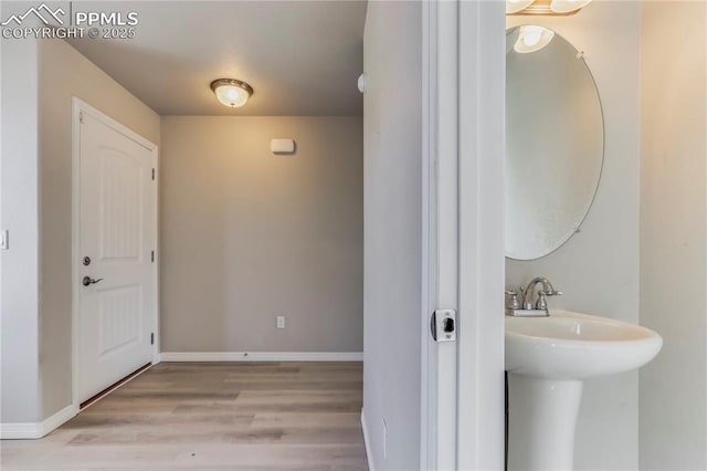 bathroom featuring a sink, baseboards, and wood finished floors