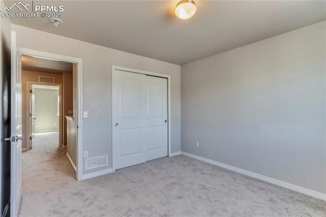 unfurnished bedroom featuring baseboards, visible vents, and carpet floors