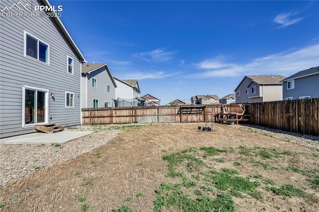 view of yard featuring a fenced backyard, a residential view, and a patio