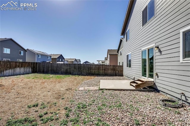 view of yard featuring a residential view, a patio, and a fenced backyard