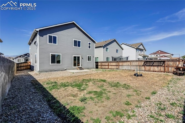 rear view of property featuring a patio and a fenced backyard