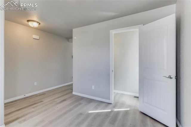 unfurnished room with wood finished floors and baseboards