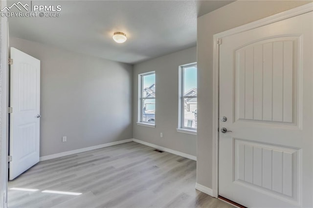 entryway with visible vents, baseboards, and light wood finished floors