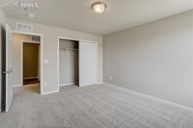 unfurnished bedroom featuring carpet floors, a closet, visible vents, and baseboards