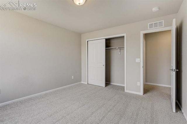 unfurnished bedroom featuring a closet, baseboards, visible vents, and carpet flooring