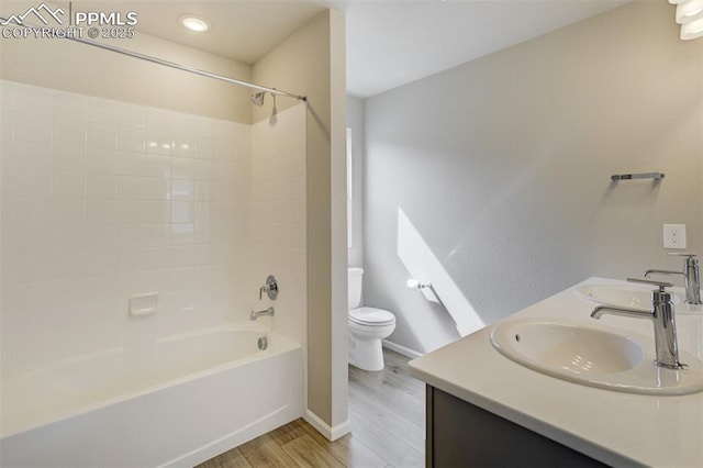 full bathroom with washtub / shower combination, a sink, toilet, and wood finished floors