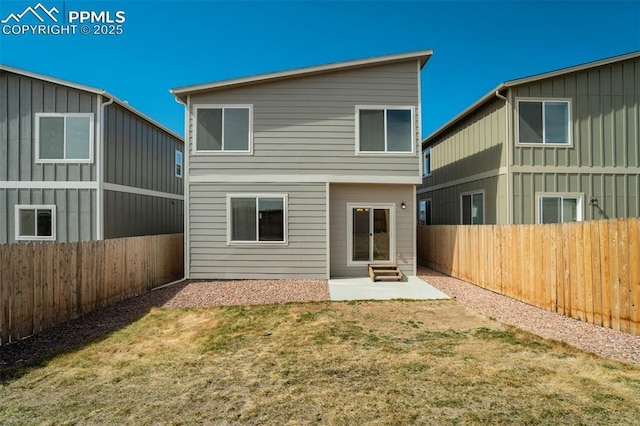 back of house featuring a fenced backyard, a patio, and a lawn