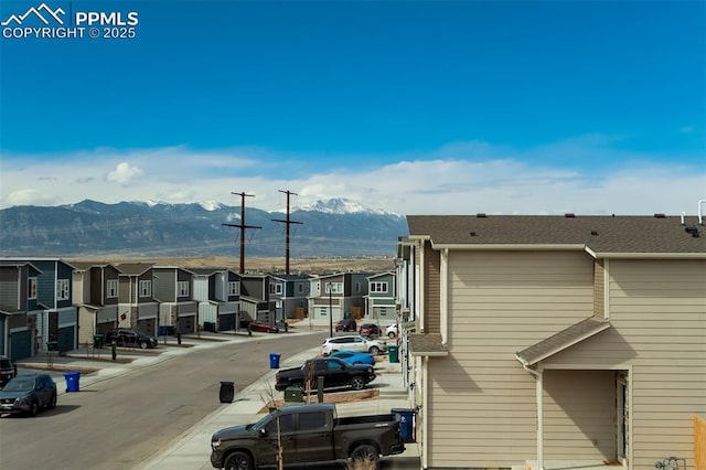 exterior space featuring a residential view, curbs, a mountain view, and sidewalks