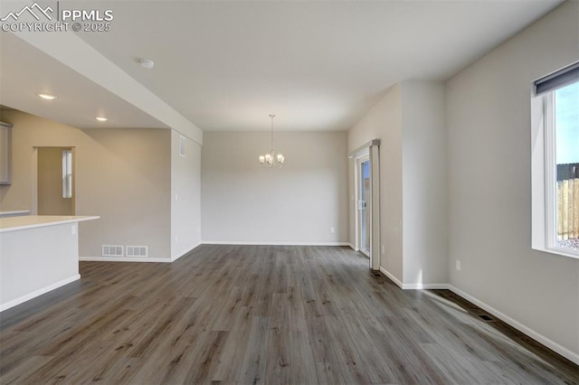 interior space featuring an inviting chandelier, visible vents, baseboards, and wood finished floors