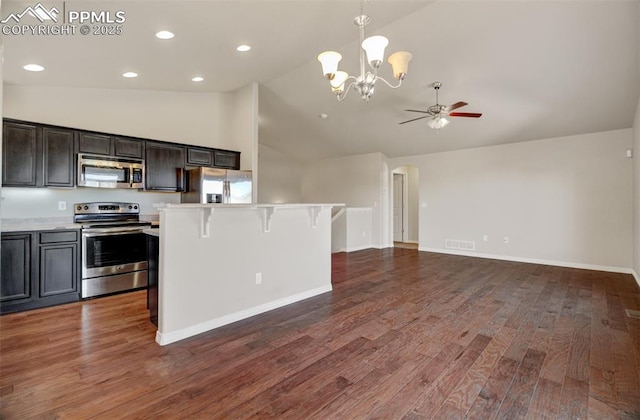 kitchen with lofted ceiling, stainless steel appliances, wood finished floors, open floor plan, and light countertops