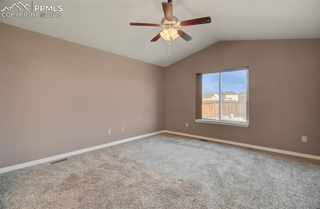 spare room with visible vents, baseboards, ceiling fan, vaulted ceiling, and carpet flooring