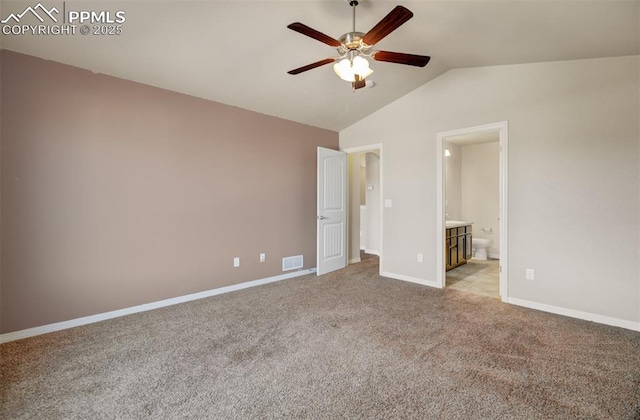 unfurnished bedroom featuring light colored carpet, visible vents, connected bathroom, vaulted ceiling, and baseboards