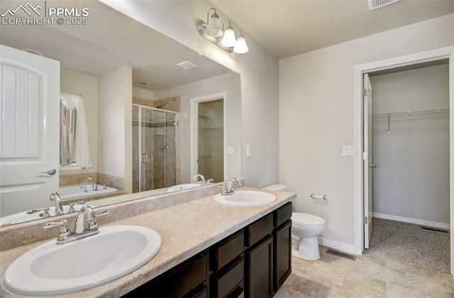 bathroom featuring a walk in closet, a sink, visible vents, and a shower stall