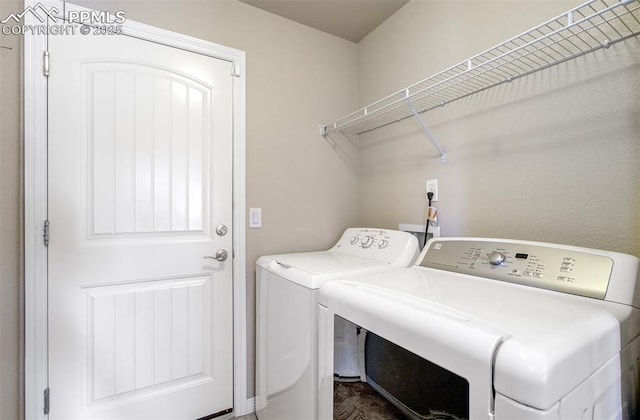 clothes washing area featuring washing machine and dryer and laundry area