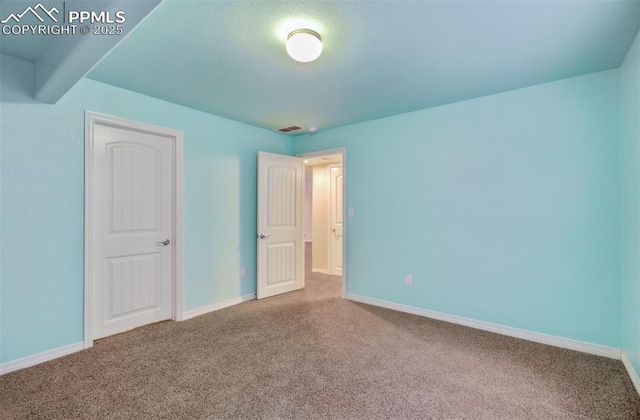 unfurnished bedroom with carpet flooring, visible vents, and baseboards