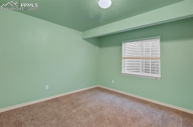 carpeted empty room with baseboards