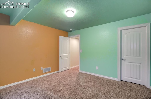 unfurnished bedroom with carpet, visible vents, and baseboards