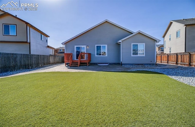 back of property featuring a patio, a lawn, a fenced backyard, and a wooden deck