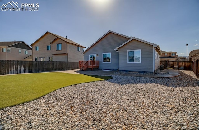 back of house featuring a deck, a lawn, a fenced backyard, and a residential view