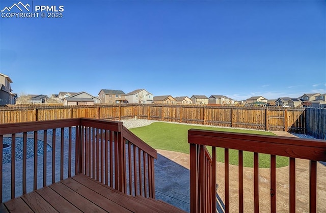 deck featuring a yard, a patio, a fenced backyard, and a residential view