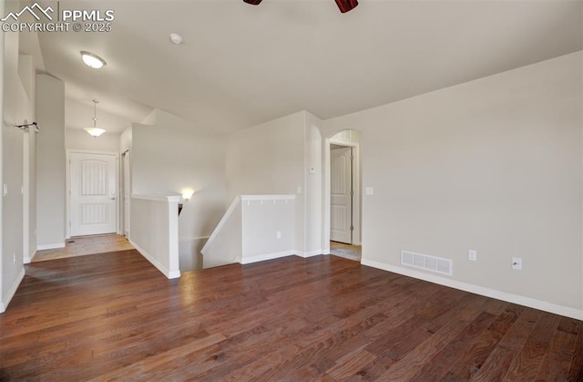 spare room featuring baseboards, visible vents, and wood finished floors