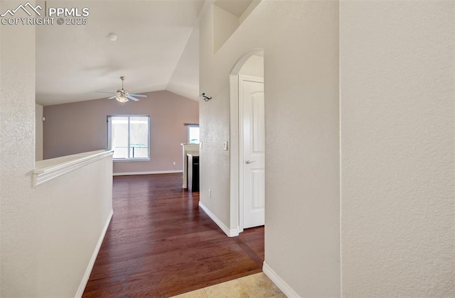 hall with vaulted ceiling, wood finished floors, and baseboards