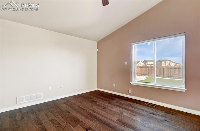 unfurnished room featuring baseboards, visible vents, vaulted ceiling, and dark wood-style flooring