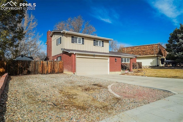 traditional home featuring brick siding, a chimney, concrete driveway, an attached garage, and fence