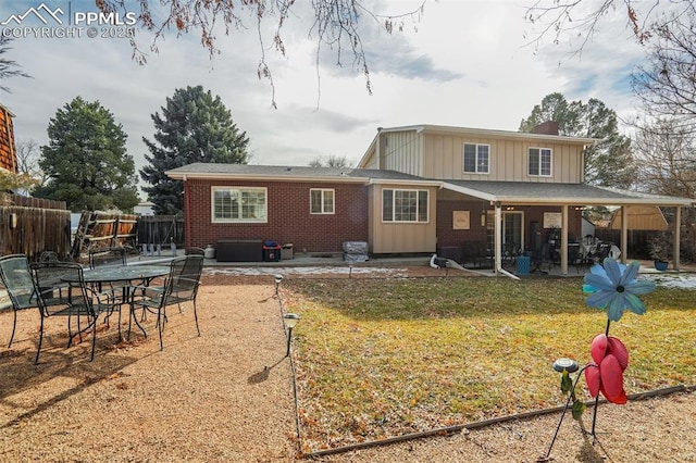 back of property featuring brick siding, a patio, a chimney, a lawn, and fence