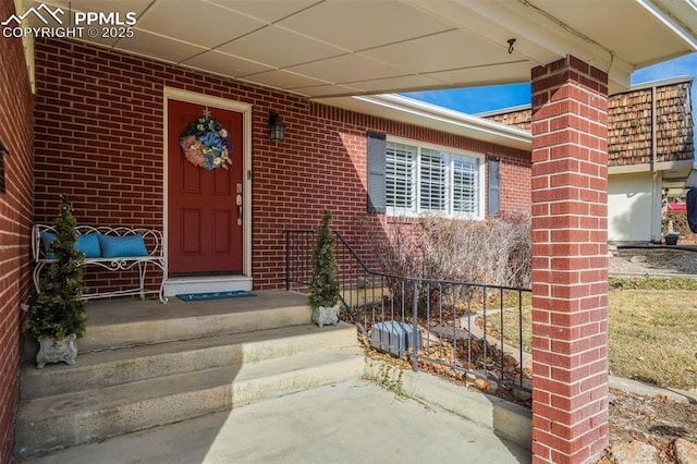 view of exterior entry featuring brick siding