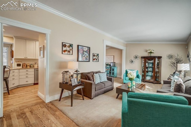 living room featuring light wood-style floors, baseboards, and crown molding