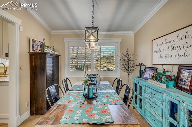 carpeted dining space with ornamental molding, a sink, and baseboards