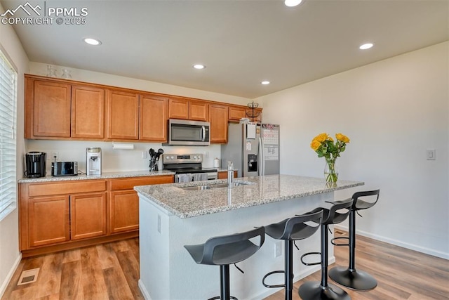 kitchen featuring visible vents, appliances with stainless steel finishes, wood finished floors, a sink, and recessed lighting