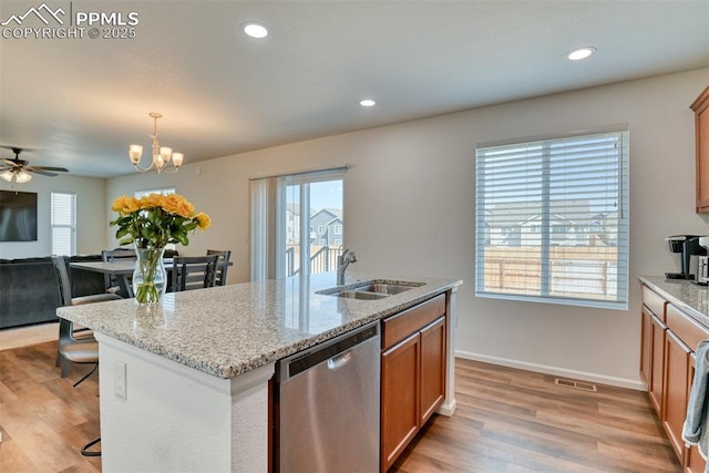 kitchen featuring a center island with sink, visible vents, stainless steel dishwasher, light wood-style floors, and a sink