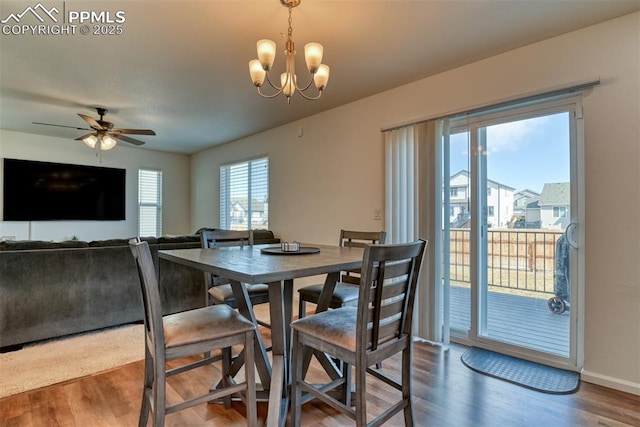 dining area with ceiling fan with notable chandelier, wood finished floors, and baseboards