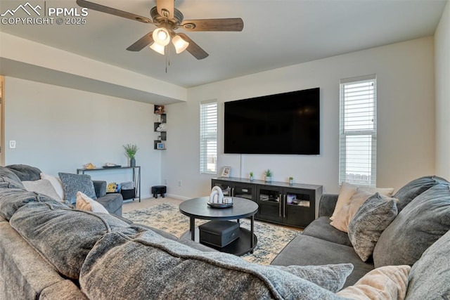 carpeted living room featuring a ceiling fan, plenty of natural light, and baseboards