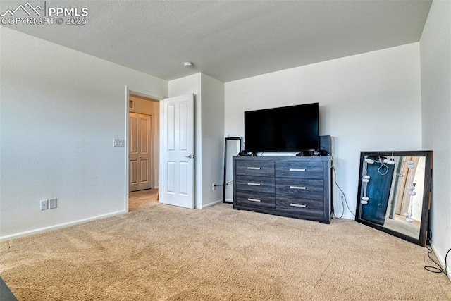 unfurnished bedroom featuring a textured ceiling, carpet, and baseboards